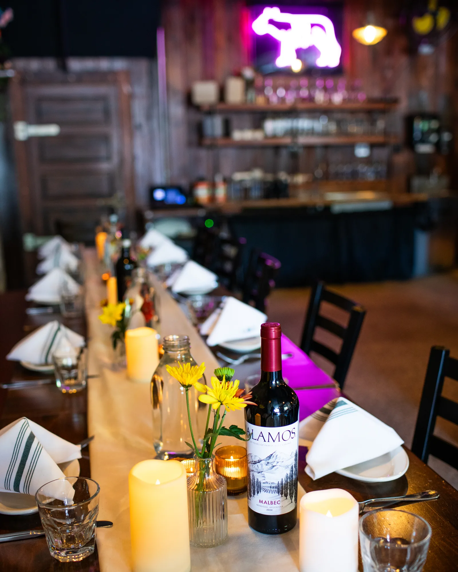 A candlelit table under the neon wolf