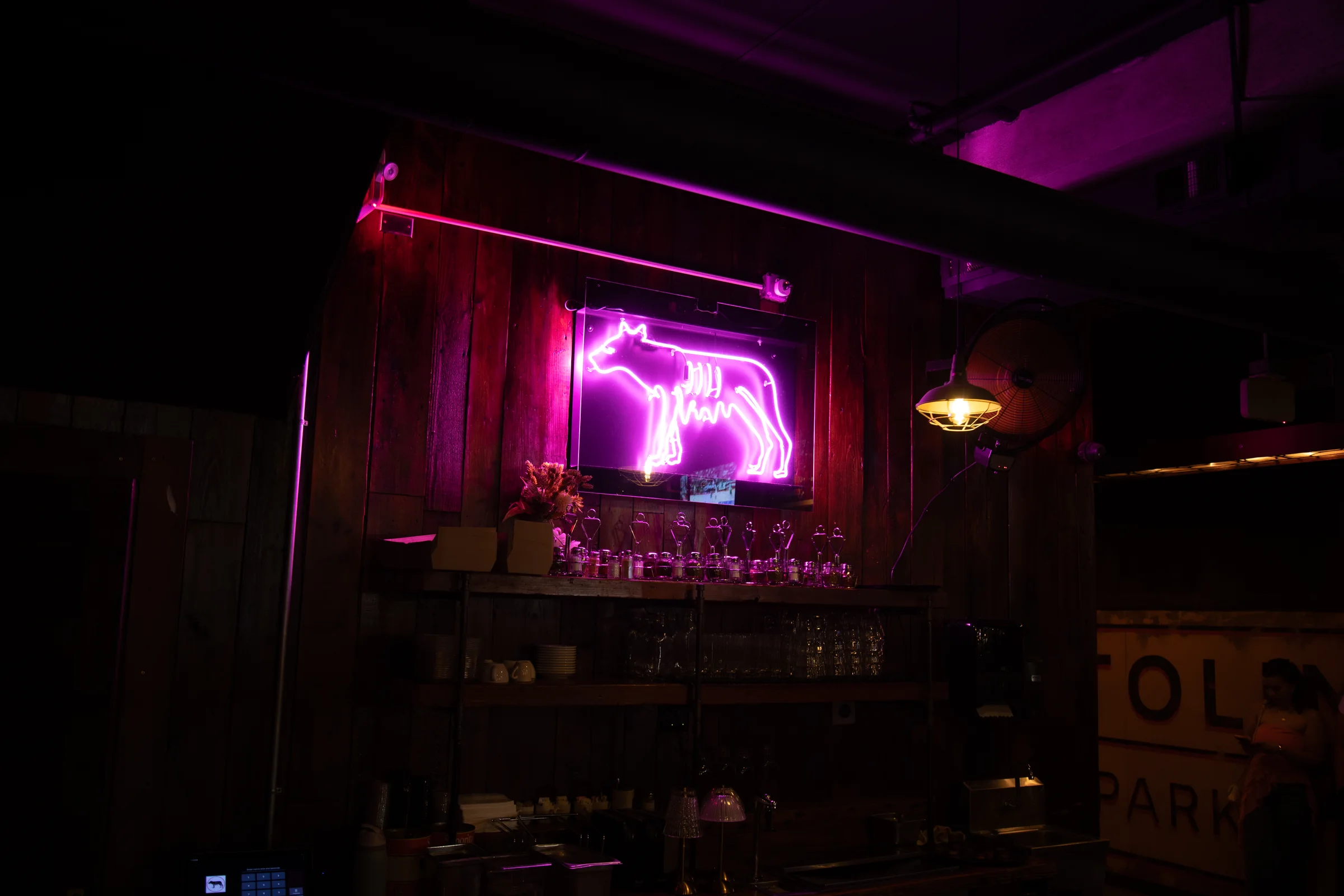 The she-wolf in pink neon over the back bar at Capitoline