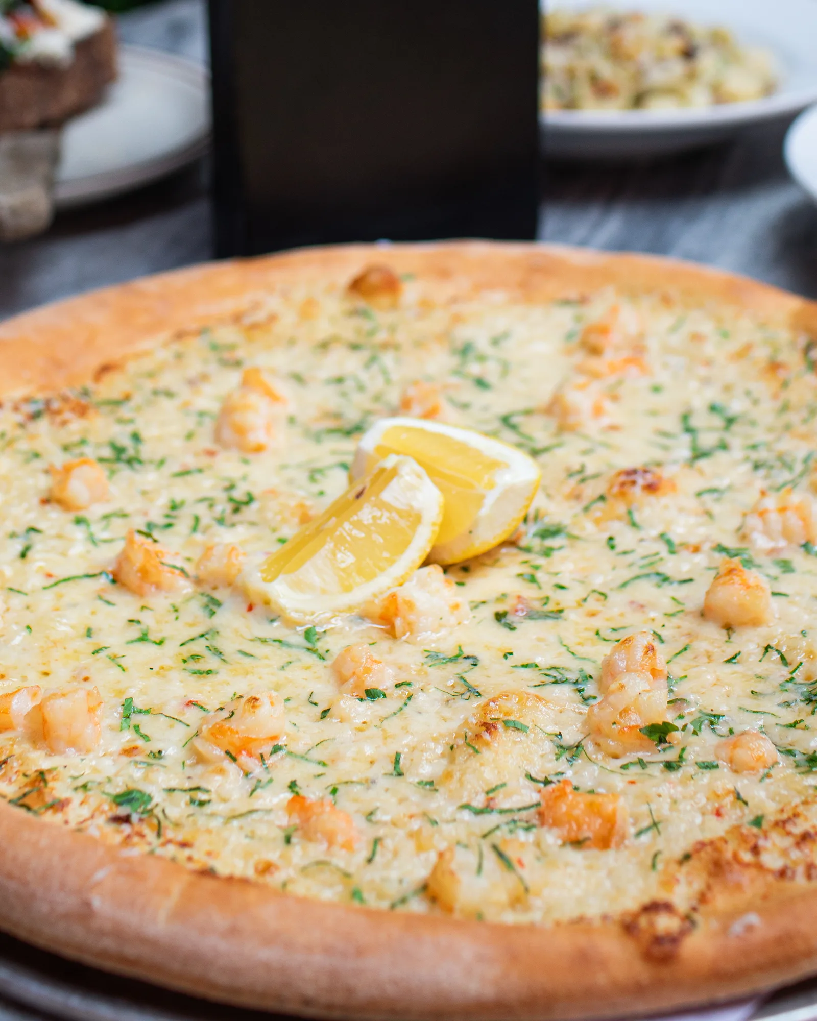 Shrimp scampi pizza — sauteed shrimp, lemon, parsley, parm